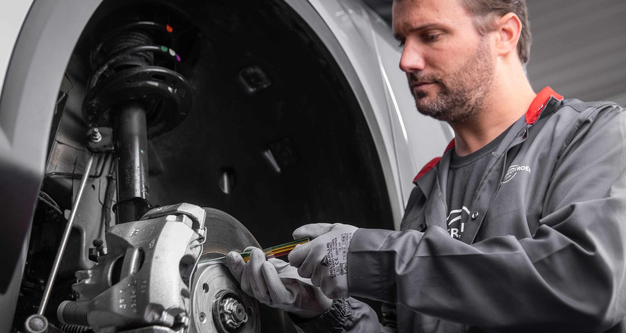 Technicien Après-Vente intervenant sur le système de freinage d'un véhicule Citroën