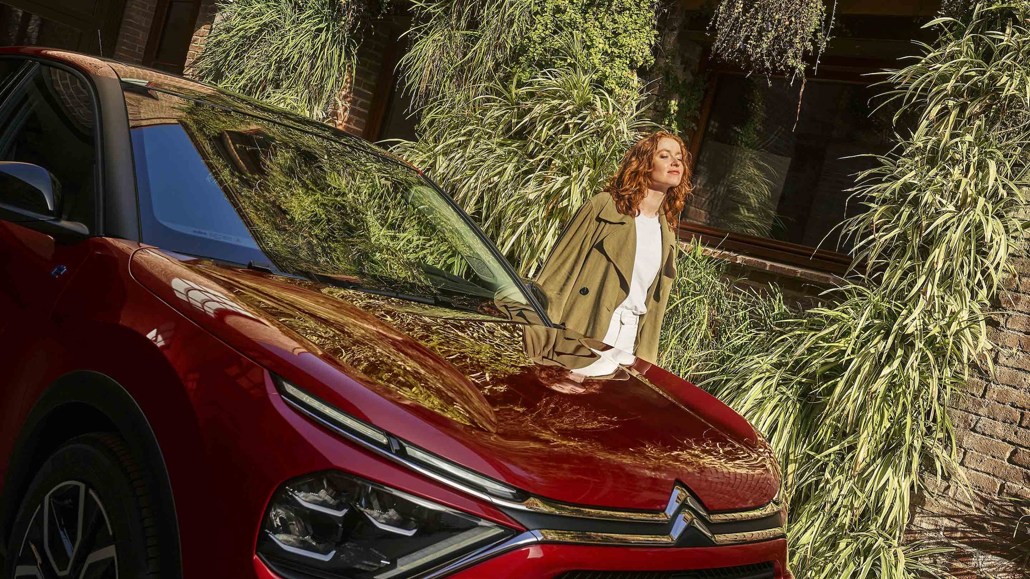 Capot de Citroën ë-C4 Rouge et femme sereine aux yeux fermés