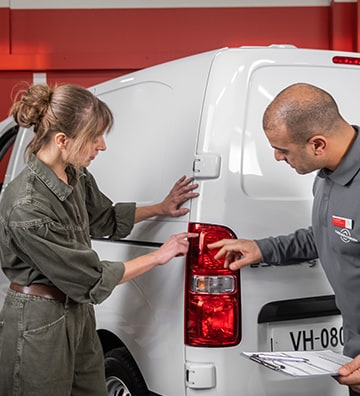 Technicien Citroën et cliente vérifiant les optiques de Jumpy