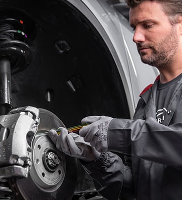 Technicien Citroën ntervenant sur le système de freinage d'un véhicule