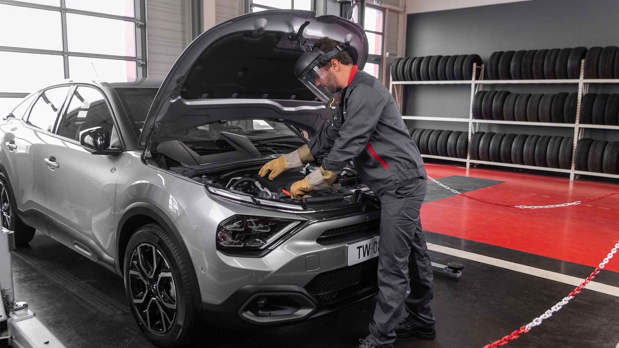 Technicien Citroën intervenant sur une Citroën ë-C4 en atelier de réparation