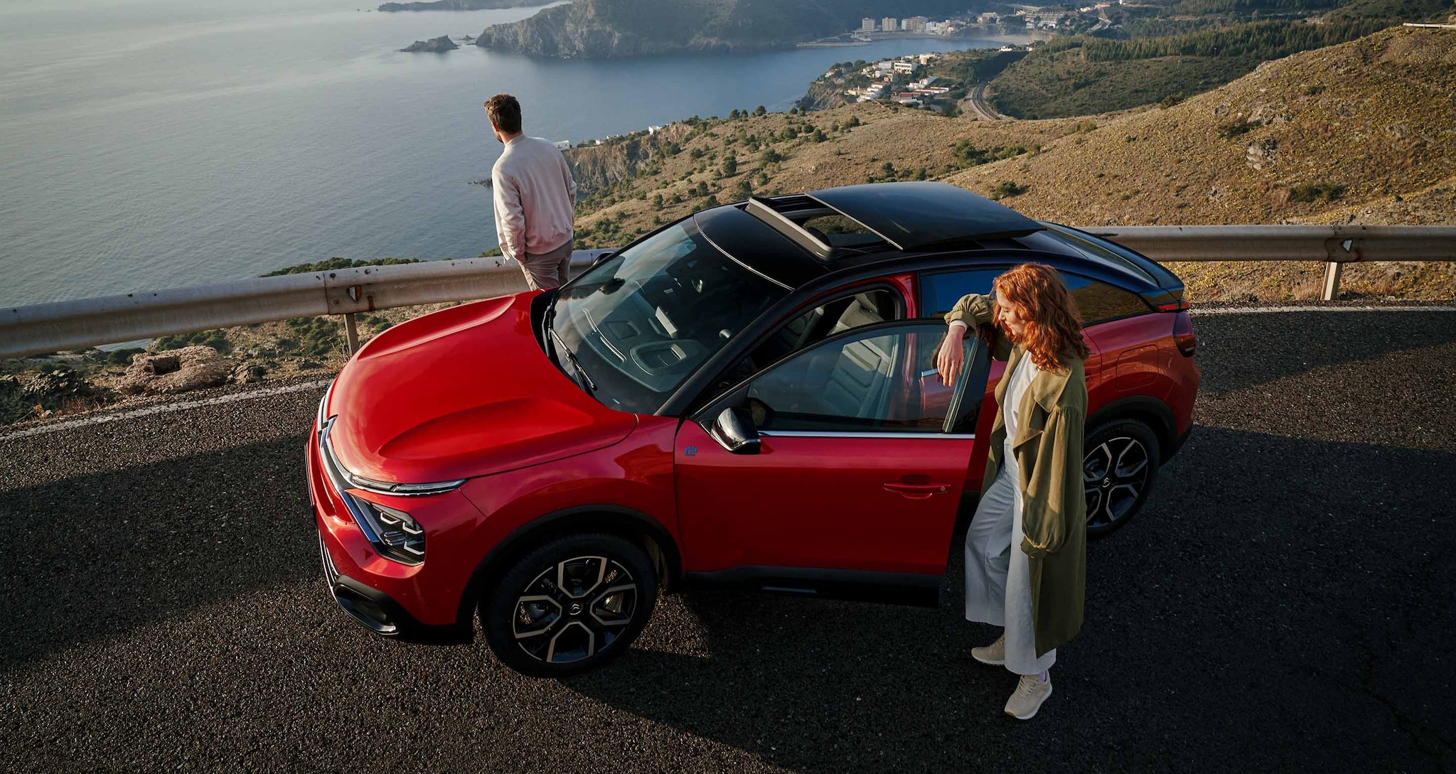 Couple aux cotés de Citroën ë-C4 Électrique Rouge Élixir